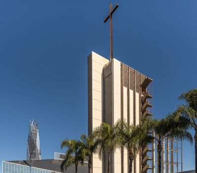 Garden Grove, California, USA - December 13, 2018: Crystal Christ Cathedral. Combination shot of Tower of hope, Church building and Crean Tower against blue sky. Green palm trees up front.