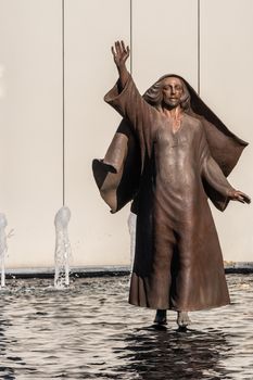 Garden Grove, California, USA - December 13, 2018: Crystal Christ Cathedral. Closeup of bronze statue of Jesus walking on water near Tower of Hope.