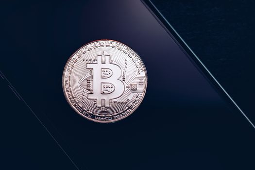 Bitcoin symbol over mobile screen, minimalist approach. Bitcoin on stock market. New digital money. Golden Bitcoin over smartphone display.