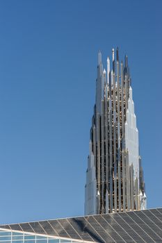 Garden Grove, California, USA - December 13, 2018: Crystal Christ Cathedral. Closeup of Crean Tower against blue sky. Roof of cathedral proper in front.