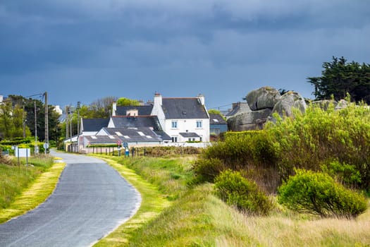 Ocean coast in Meneham village with granite rocks and boats, Kerlouan, Finistere, Brittany (Bretagne), France