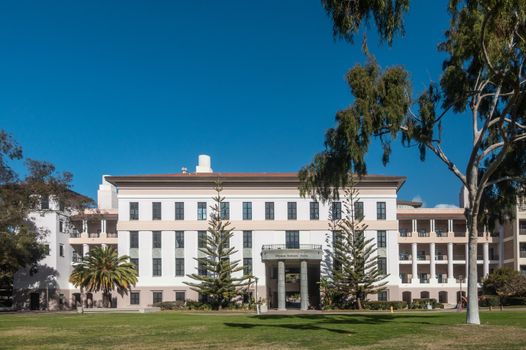 Santa Barbara, California, USA - January 6, 2019: The white and beige modern Physical Sciences North building of UCSB, behind green lawn, trees, and under blue sky.