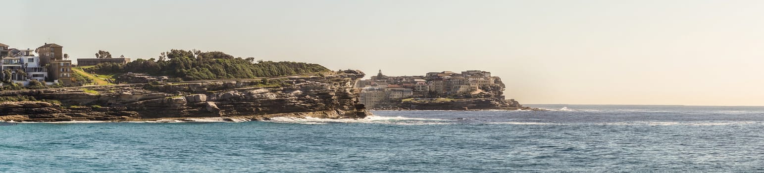 Sydney, Australia - February 11, 2019: Panorama shot of Bronte Beach, sea water under gray sky, seen from South cliff. 