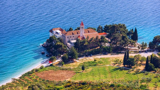 View of beautiful bay with beach and Dominican monastery in Bol town, Brac island, Croatia. Dominican monastery in Bol, built in 15th century. Bol town, Brac island, Croatia.