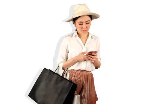 Young asian woman to see a smartphone and hold shopping bag