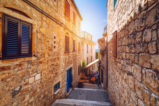 Beautiful street with flowers in the Hvar town, Hvar island, Dalmatia, Croatia. Old Mediterranean street, Hvar town. Old Adriatic town Hvar. Medieval street. Popular touristic destination of Croatia.