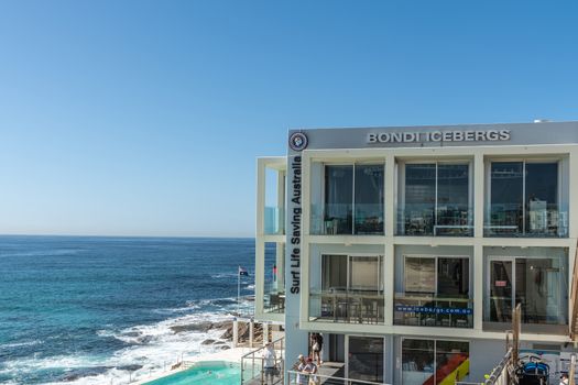 Sydney, Australia - February 11, 2019: Bondi Icebergs Club House and Surf Life Savings with pool. Blue sea and sky. People in photo.