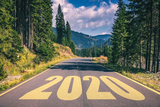 Empty asphalt road and New year 2020 concept. Driving on an empty road in the mountains to upcoming 2020 and leaving behind old 2019. Concept for success and passing time.
