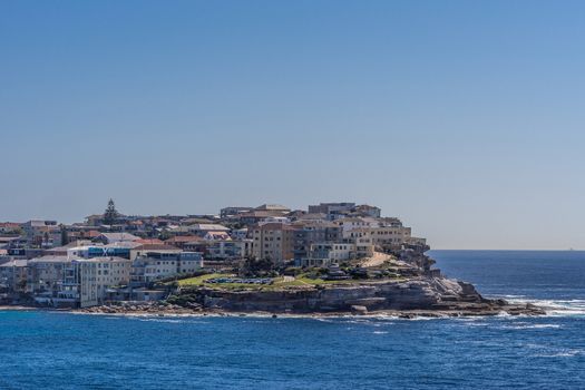 Sydney, Australia - February 11, 2019: Lands end with Sam Fiszman Park and buildings under blue sky and surrounded by blue sea water.