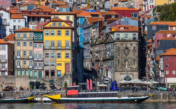 Colorful houses of Porto Ribeira, traditional facades, old multi-colored houses with red roof tiles on the embankment in the city of Porto, Portugal