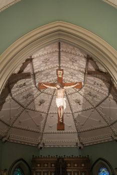 Sydney, Australia - February 12, 2019: Inside Saint Patricks Church on Grosvenor Street opposite of Lang Park. Jesus Christ on the cross suspended from the ceiling above the altar in chancel.
