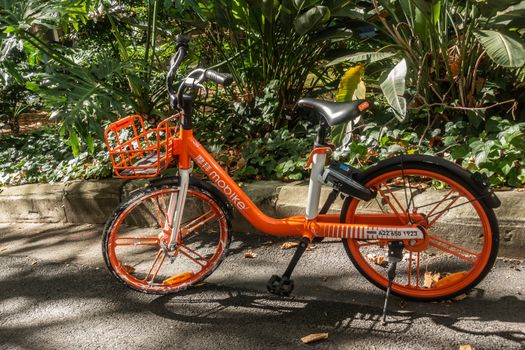 Sydney, Australia - February 12, 2019: Closeup of parked orange MOBIKE bicycle for rent as seen in Lang Park.
