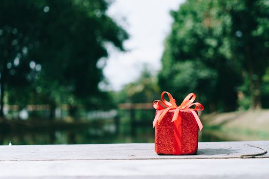 Gift or present boxes on green bokeh nature background.