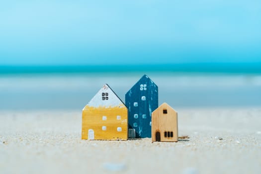 Model of a little house on sand with nature beach background. Dream life concept.