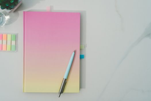 colorful pastel white notebook for journal or diary on marble texture table.