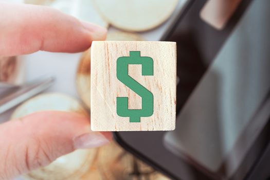 Dollar sign letterpress design on wooden cube decorate with calculator stationary gold coin. Business financial investing home property concept.