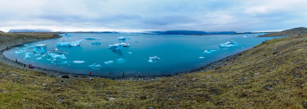 JOKULSARLON, ICELAND - JUNE 13, 2016: Panoramic view of the Jokulsarlon glacier lagoon, with visitors, in southeastern Iceland