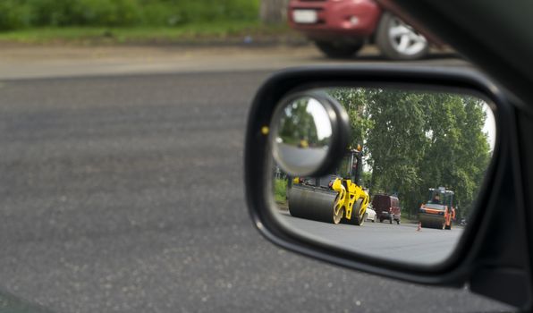 the reflection in the mirror of the repair of the road