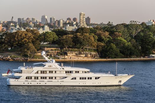 Sydney, Australia - February 12, 2019: The white luxurious Callisto yacht in the bay under an evening twilight sky.