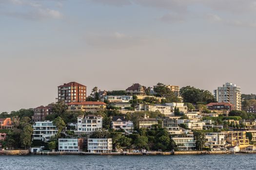 Sydney, Australia - February 12, 2019: Upscale neighborhood around Duff Reserve bordering the bay shows fancy housing under an evening twilight sky.
