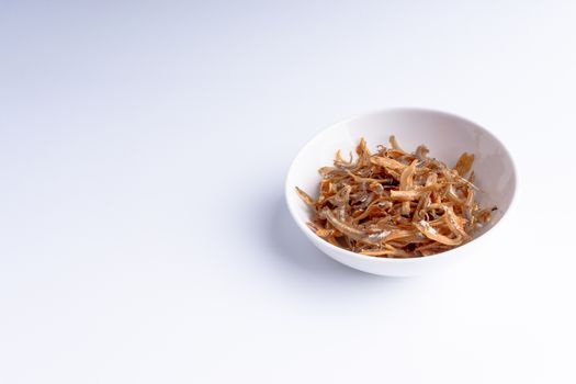 Fried anchovies in bowl close up with selective focus and crop fragment