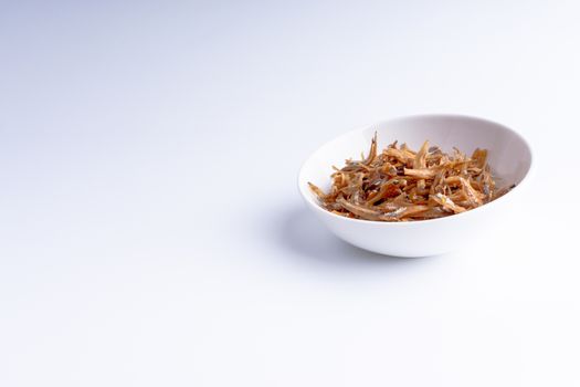 Fried anchovies in bowl close up with selective focus and crop fragment