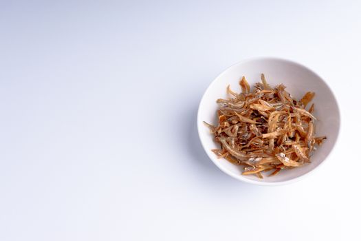 Fried anchovies in bowl close up with selective focus and crop fragment