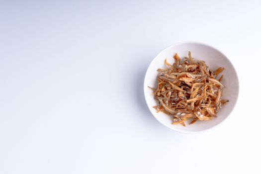 Fried anchovies in bowl close up with selective focus and crop fragment