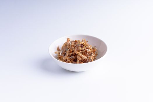 Fried anchovies in bowl close up with selective focus and crop fragment