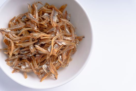 Fried anchovies in bowl close up with selective focus and crop fragment