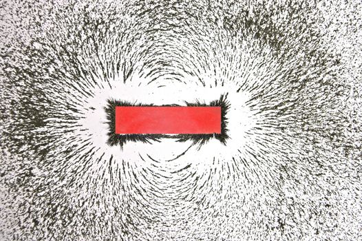 Bar magnet with iron filings showing magnetic field pattern