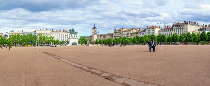 Lyon, France - May 09, 2019: Panoramic view of Place Bellecour square, with the equestrian statue of Louis XIV, locals and visitors, in Lyon, France