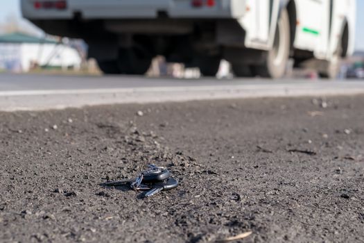 Lost bunch of keys lying on the side of the road near the asphalt pavement of the roadway