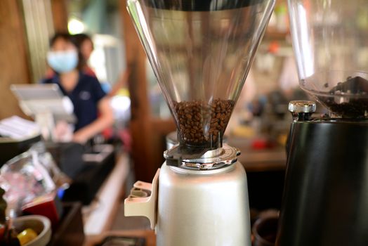 Close up of fresh roasted coffee beans in maker at cafe