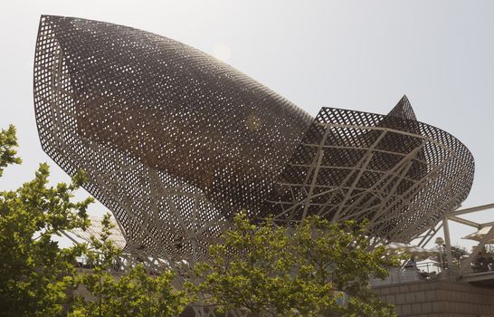BARCELONA, SPAIN - JULY 4, 2015: Frank Gehry's modern El Peix d'Or sculpture is located in Barcelona's Vila Olimpica, Olympic Village for the 1992 Olympic games.

Barcelona, Spain - July 4, 2015: Frank Gehry's modern El Peix d'Or sculpture is located in Barcelona's Vila Olimpica, Olympic Village for the 1992 Olympic games.