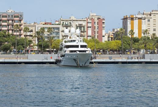 BARCELONA, SPAIN - JULY 4, 2015: Contemporary yacht moored in the harbor Port Vell. Yacht port on the famous promenade in the city center, which is visited annually by thousands of tourists.

Barcelona, Spain - July 4, 2015: Contemporary yacht moored in the harbor of Barcelona called Port Vell. Yacht port on the famous promenade in the city center, which is visited annually by thousands of tourists.
