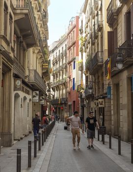 BARCELONA, SPAIN - JULY 6, 2015: Old streets of Barrio Gotico in Barcelona, Catalonia.

Barcelona, Spain - July 6, 2015: Old streets of Barrio Gotico in Barcelona, Catalonia. People are walking by street.