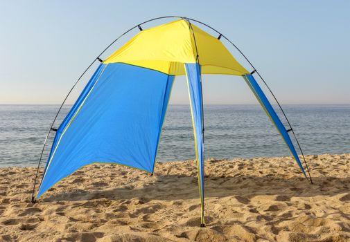 Blue and yellow nylon tent at the beach.