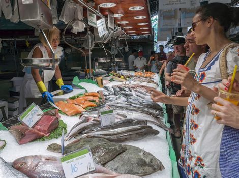 BARCELONA, SPAIN - JULY 6, 2015: Fresh fish in Sant Josep de la Boqueria Market in Barcelona. The market is the best known and visited by tourists in Barcelona. People are buying fish in the Boqueria market.

Barcelona, Spain - July 6, 2015: Fresh fish in Sant Josep de la Boqueria Market in Barcelona. The market is the best known and visited by tourists in Barcelona. People are buying fish in the Boqueria market.