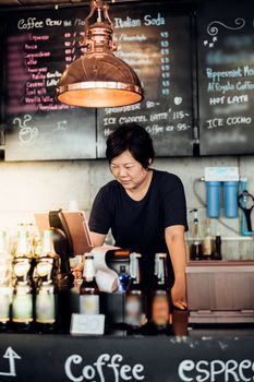 Asian woman 40s white skin plump body is coffee shop owner work as a cashier service to customers in the coffee shop cafe