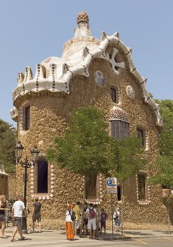 BARCELONA, SPAIN - JULY 6, 2015: Architecture of Park Guell by architect Antonio Gaudi.

Barcelona, Spain - July 6, 2015: Architecture of Park Guell by architect Antonio Gaudi. People are standing near entrance.