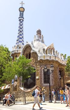 BARCELONA, SPAIN - JULY 6, 2015: Architecture of Park Guell by architect Antonio Gaudi.

Barcelona, Spain - July 6, 2015: Architecture of Park Guell by architect Antonio Gaudi. People are walking by street.