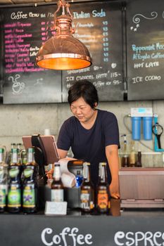 Asian woman 40s white skin plump body is coffee shop owner work as a cashier service to customers in the coffee shop cafe