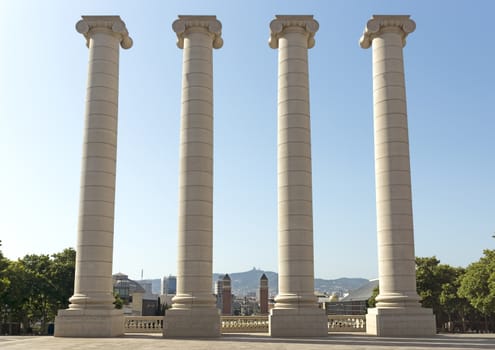 BARCELONA, SPAIN - JULY 6, 2015: The Four Columns, created by Josep Puig i Cadafalch, is on the place in front of Museu Nacional d'Art de Catalunya, Barcelona, Spain.

Barcelona, Spain - July 6, 2015: National Palace of Barcelona, with the four pillars that symbolize the Catalan flag. Built following the Barcelona International Exposition of 1929, held in the mountain of Montjuic. Today is the National Museum of Catalan Art (MNAC).