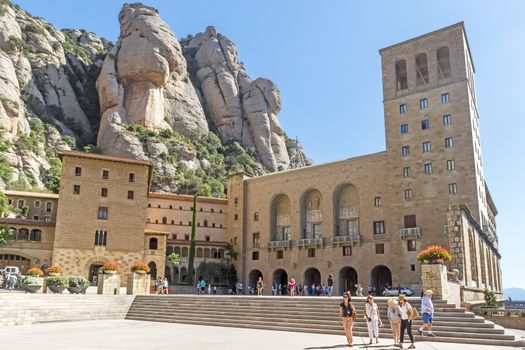 BARCELONA, SPAIN - JULY 10, 2015: The Benedictine abbey Santa Maria de Montserrat in Monistrol de Montserrat, Spain. It hosts the Virgin of Montserrat, the favourite in Catalonia.

Barcelona, Spain - July 10, 2015: The Benedictine abbey Santa Maria de Montserrat in Monistrol de Montserrat. It hosts the Virgin of Montserrat, the favourite in Catalonia. Montserrat Monastery located high up in the mountains near Barcelona, Spain. People are visiting the Monastery.