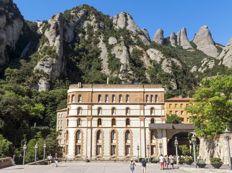 BARCELONA, SPAIN - JULY 10, 2015: The Benedictine abbey Santa Maria de Montserrat in Monistrol de Montserrat, Spain. It hosts the Virgin of Montserrat, the favourite in Catalonia.

Barcelona, Spain - July 10, 2015: The Benedictine abbey Santa Maria de Montserrat in Monistrol de Montserrat. It hosts the Virgin of Montserrat, the favourite in Catalonia. Montserrat Monastery located high up in the mountains near Barcelona, Spain. People are visiting the Monastery.