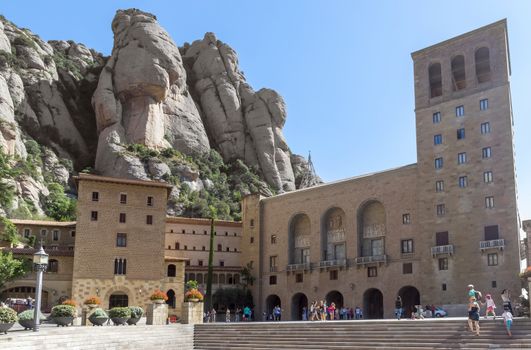 BARCELONA, SPAIN - JULY 10, 2015: The Benedictine abbey Santa Maria de Montserrat in Monistrol de Montserrat, Spain. It hosts the Virgin of Montserrat, the favourite in Catalonia.

Barcelona, Spain - July 10, 2015: The Benedictine abbey Santa Maria de Montserrat in Monistrol de Montserrat. It hosts the Virgin of Montserrat, the favourite in Catalonia. Montserrat Monastery located high up in the mountains near Barcelona, Spain. People are visiting the Monastery.