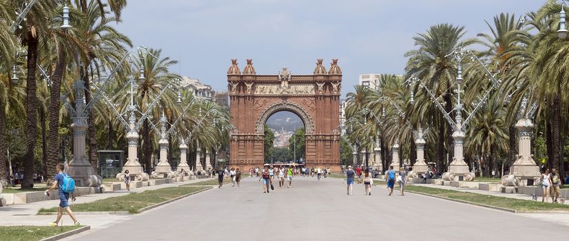 BARCELONA, SPAIN - JULY 12, 2015: Arc de Triomf at the end of a promenade leading to the Parc de la Ciutadella in Barcelona.

Barcelona, Spain - July 12, 2015: Arc de Triomf at the end of a promenade leading to the Parc de la Ciutadella in Barcelona. People are walking to Parc de la Ciutadella.