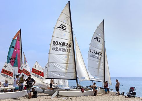 BARCELONA, SPAIN - JULY 13, 2015: People prepare yachts for surfing. Municipal Nautical Barcelona - surfing club for children and adult. Located in Park Poblenou, Barcelona, Spain.

Barcelona, Spain - July 13, 2015: People prepare yachts for surfing. Municipal Nautical Barcelona - surfing club for children and adult. Located in Park Poblenou, Barcelona, Spain.