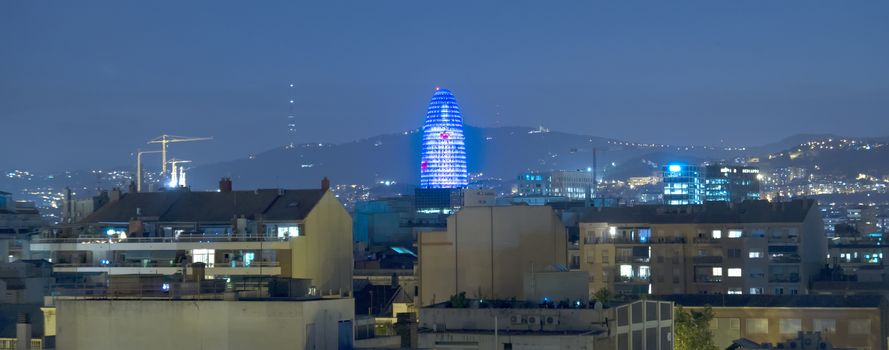 BARCELONA, SPAIN - JULY 14, 2015: Torre Agbar at night from residential district of barcelona. The tower has a total of 50693 square metres, of which 30000 are in offices.

Barcelona, Spain - July 14, 2015: Torre Agbar at night from residential district of barcelona. The tower has a total of 50693 square metres, of which 30000 are in offices.